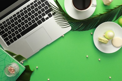 Photo of Flat lay composition with laptop on green background. Fashion blogger
