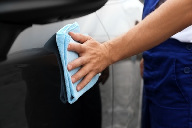 Photo of Man washing car door with rag, closeup