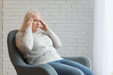 Photo of Mature woman suffering from headache at home