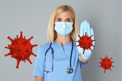 Image of Stop Covid-19 outbreak. Doctor wearing medical mask surrounded by virus on light background