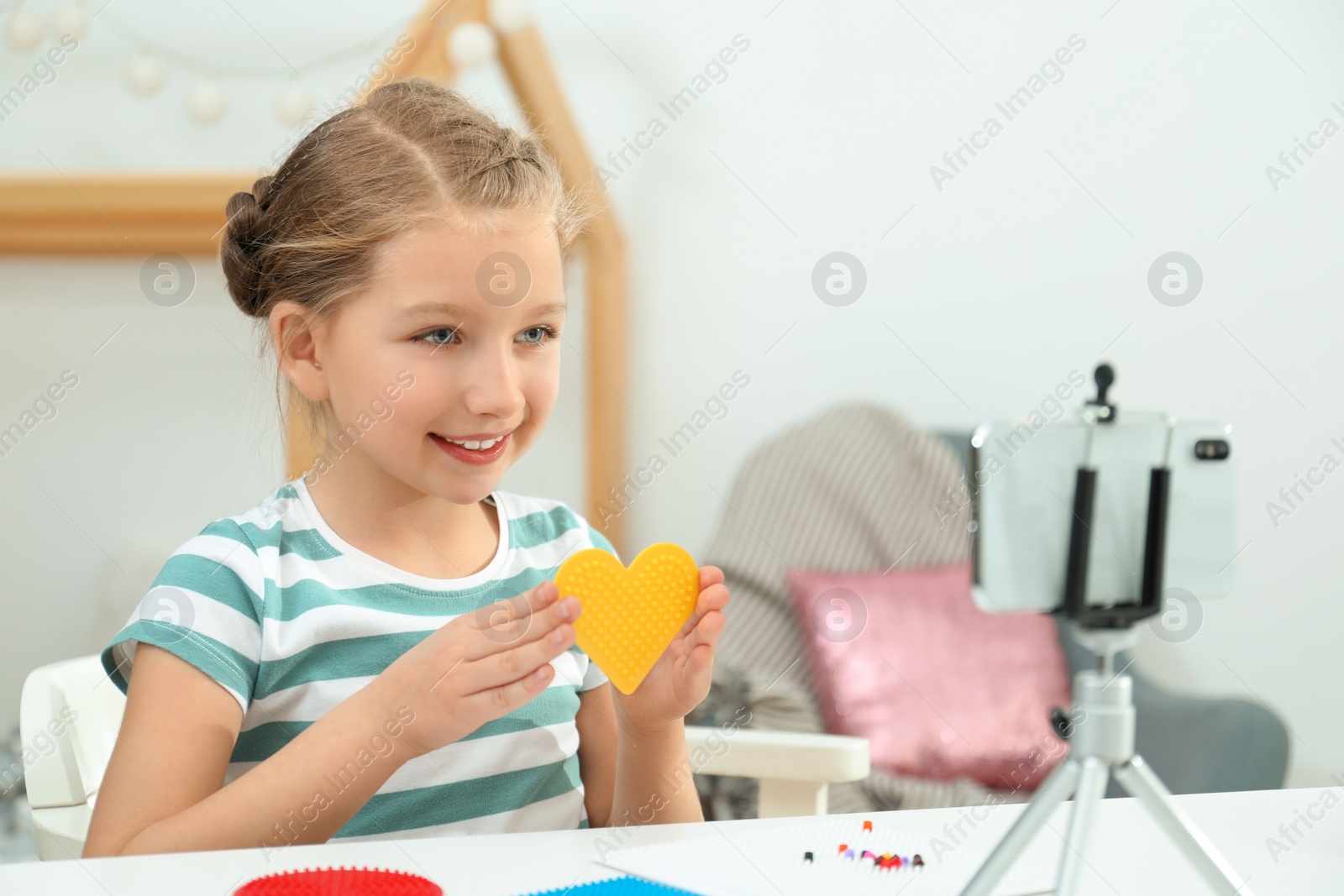 Photo of Cute little blogger with handcrafting recording video at home