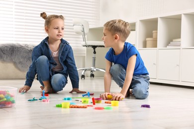 Cute little children playing on warm floor at home. Heating system