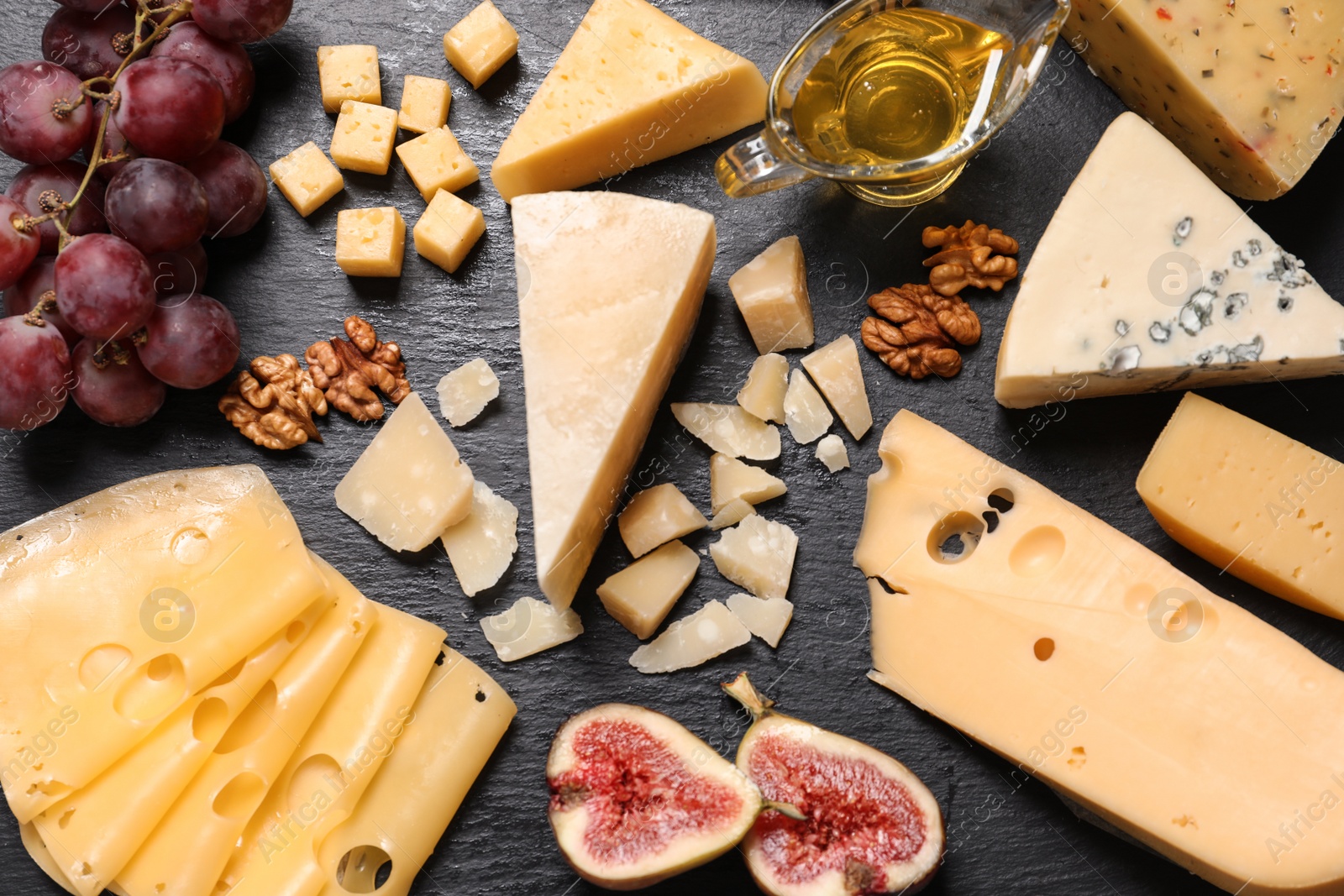 Photo of Flat lay composition with different types of delicious cheese on slate board