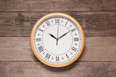 Stylish round clock on wooden table, top view. Interior element