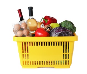 Shopping basket with grocery products on white background