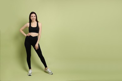 Photo of Happy young woman with slim body posing on green background