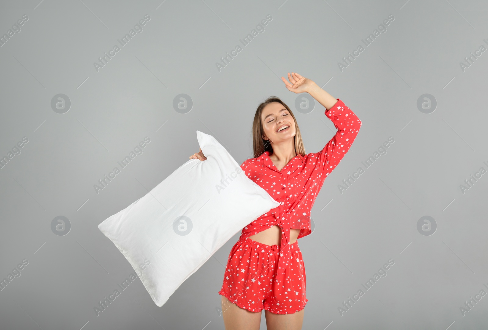 Photo of Young woman with pillow on grey background