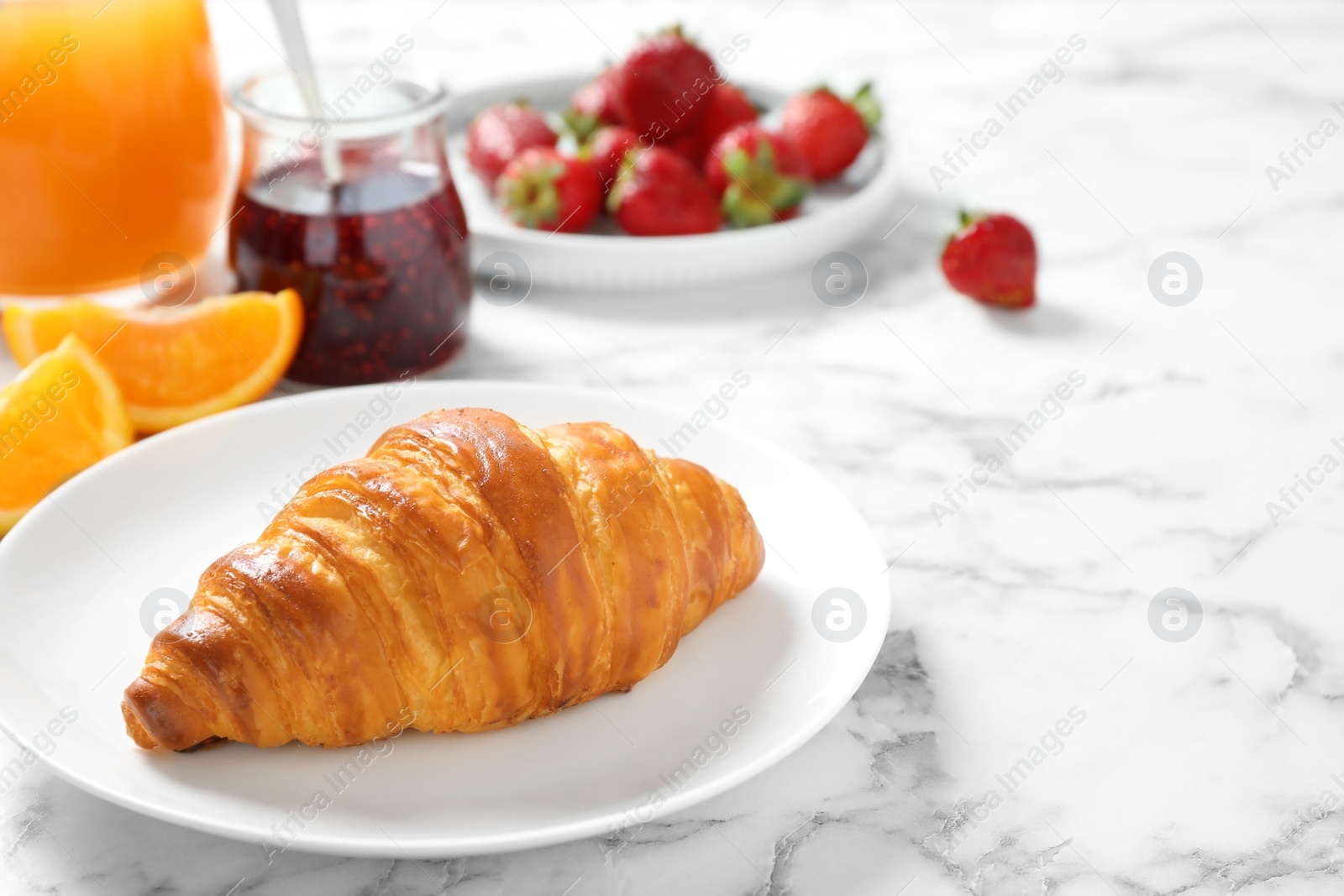 Photo of Tasty breakfast with croissant served on white marble table