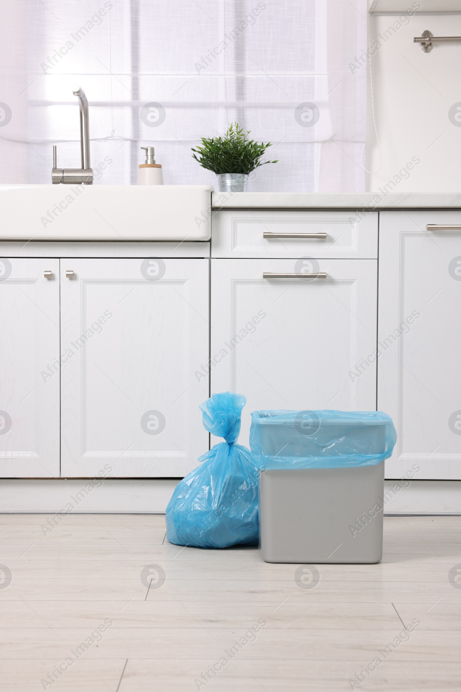 Photo of Plastic garbage bag and trash can in kitchen