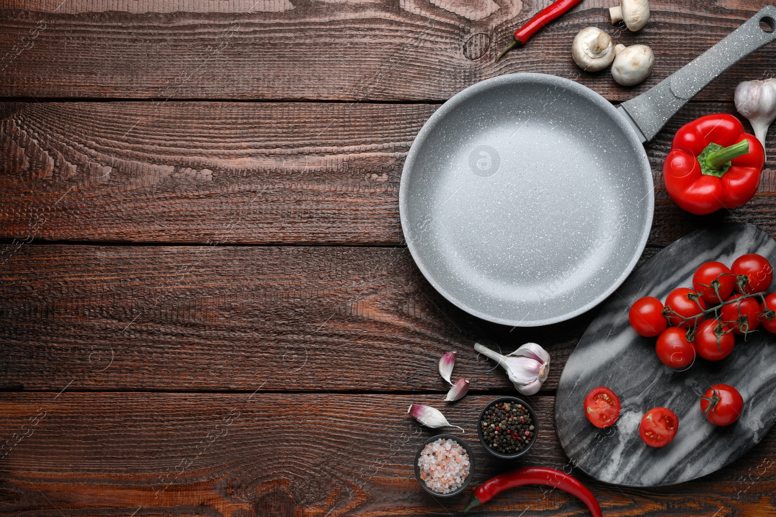 Photo of Flat lay composition with frying pan and fresh products on wooden table, space for text
