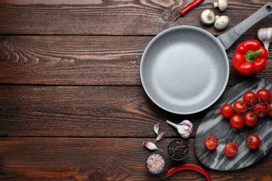 Photo of Flat lay composition with frying pan and fresh products on wooden table, space for text