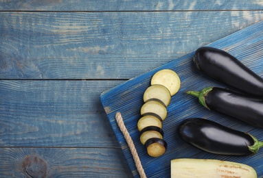 Photo of Flat lay composition with ripe eggplants on wooden background