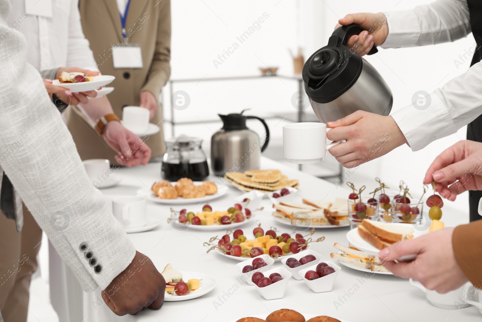 Photo of Waitress pouring hot drink during coffee break, closeup