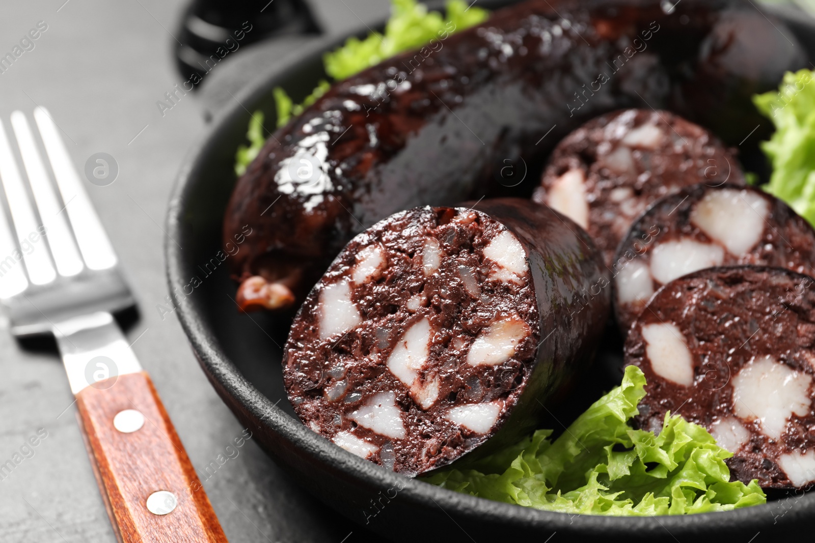 Photo of Tasty blood sausages served on grey table, closeup