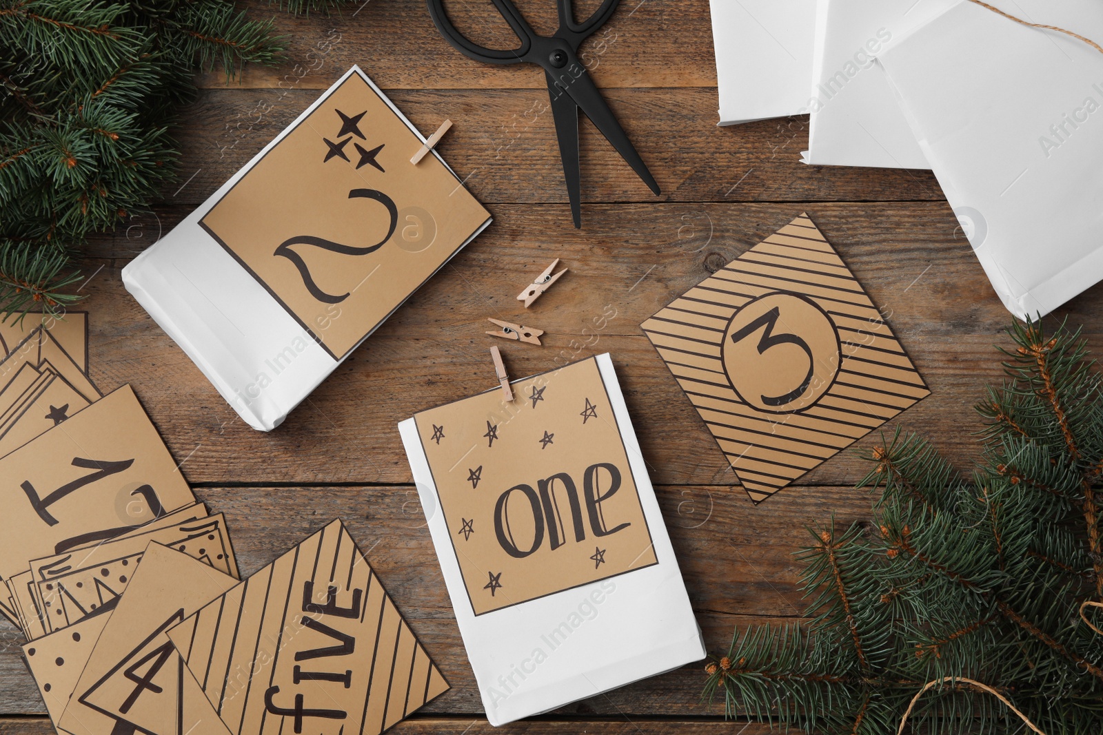 Photo of Flat lay composition with gift bags on wooden table. Creating advent calendar