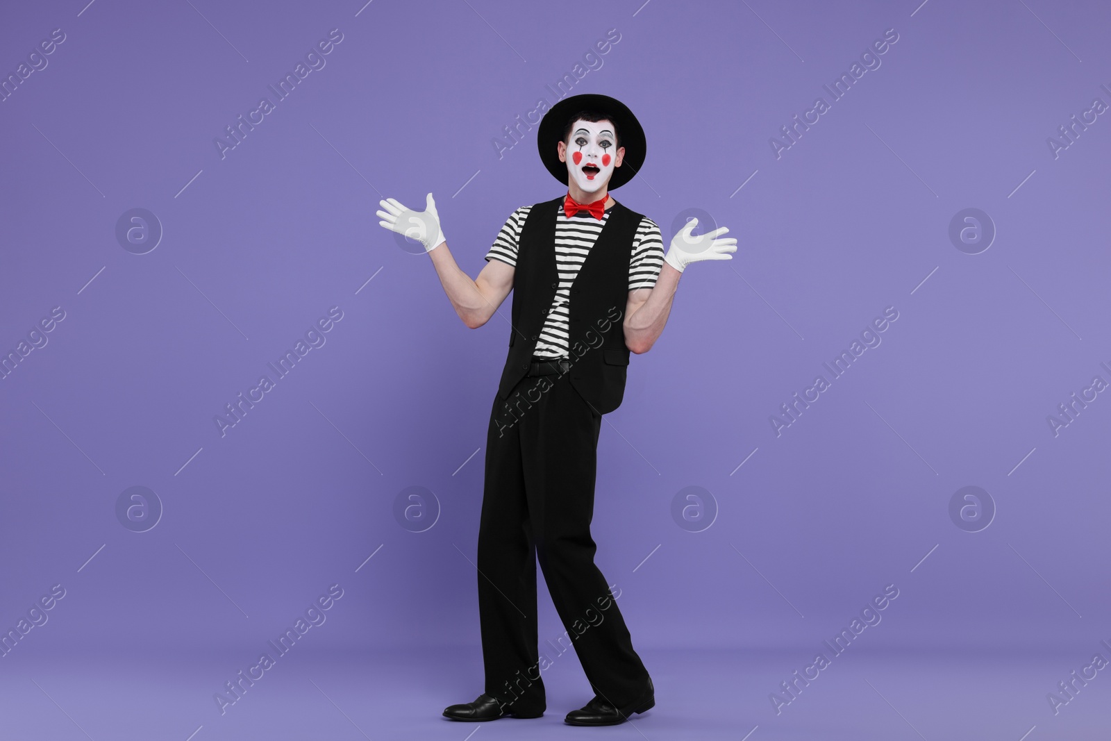 Photo of Mime artist making shocked face on purple background