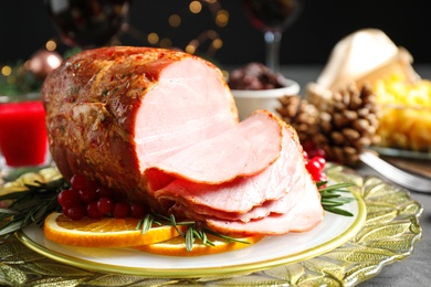 Photo of Plate with delicious ham served on grey table. Christmas dinner