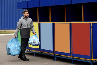 Man throwing garbage at recycling point outdoors