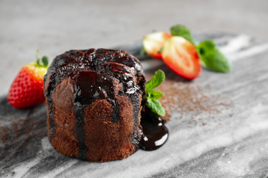 Delicious warm chocolate lava cake on marble board, closeup