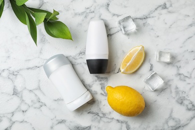Photo of Flat lay composition with different deodorants on marble table