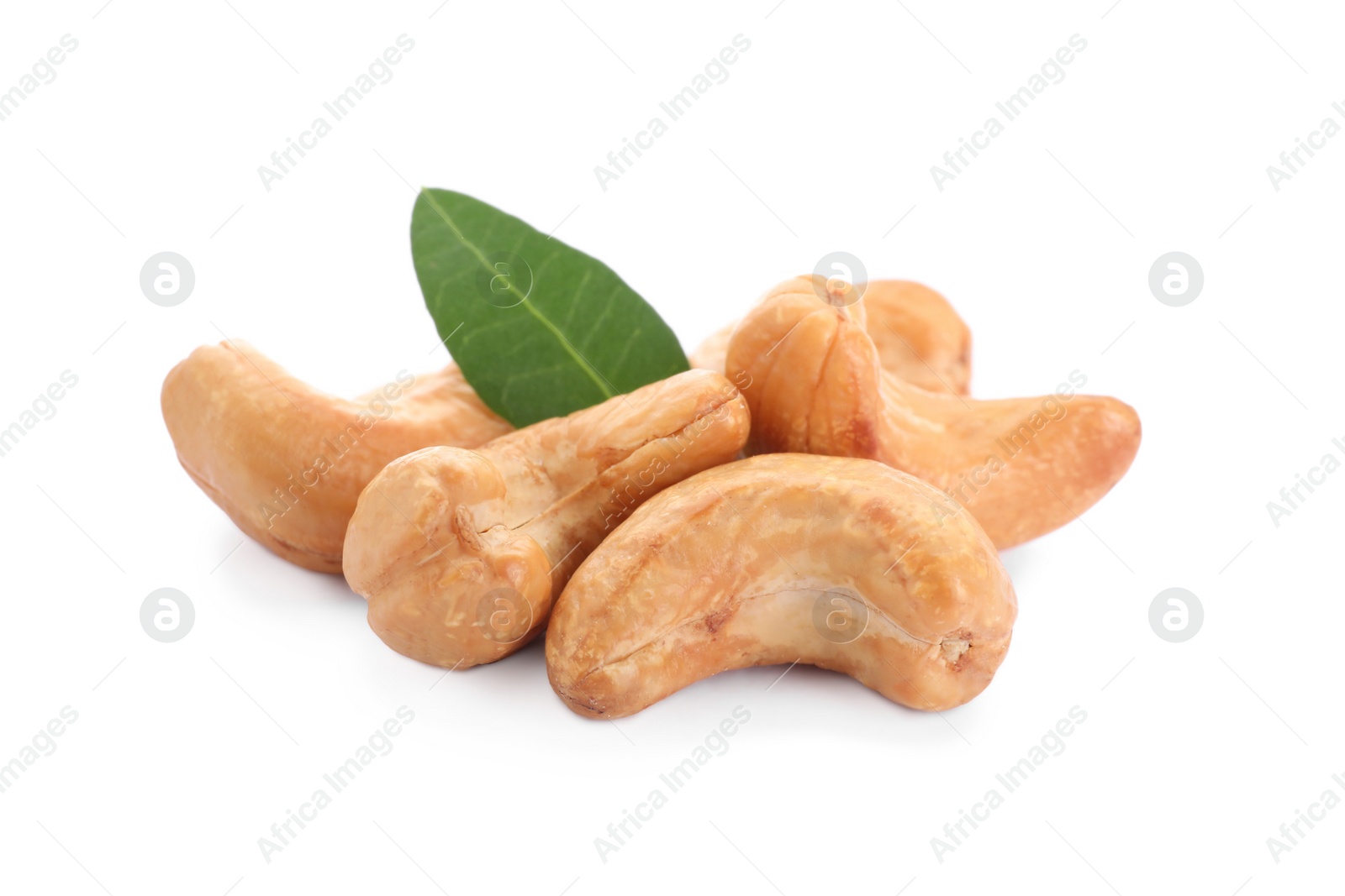 Photo of Pile of tasty organic cashew nuts and green leaf isolated on white