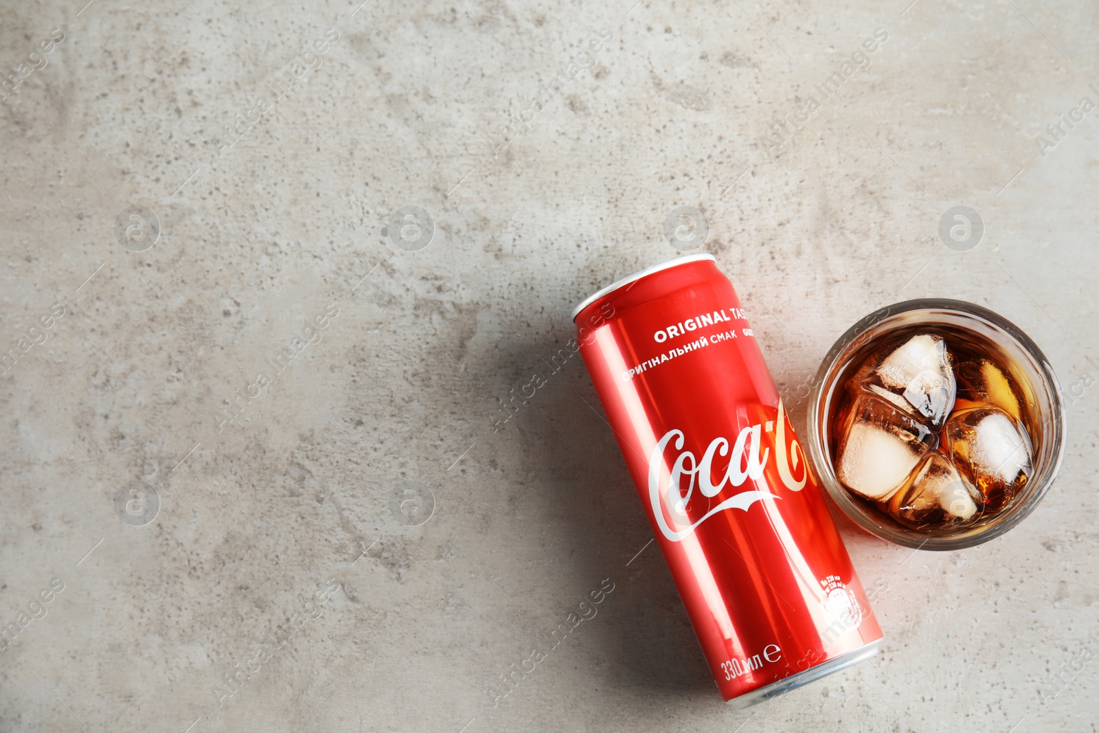 Photo of MYKOLAIV, UKRAINE - NOVEMBER 15, 2018: Glass and can with Coca Cola on table, top view. Space for text