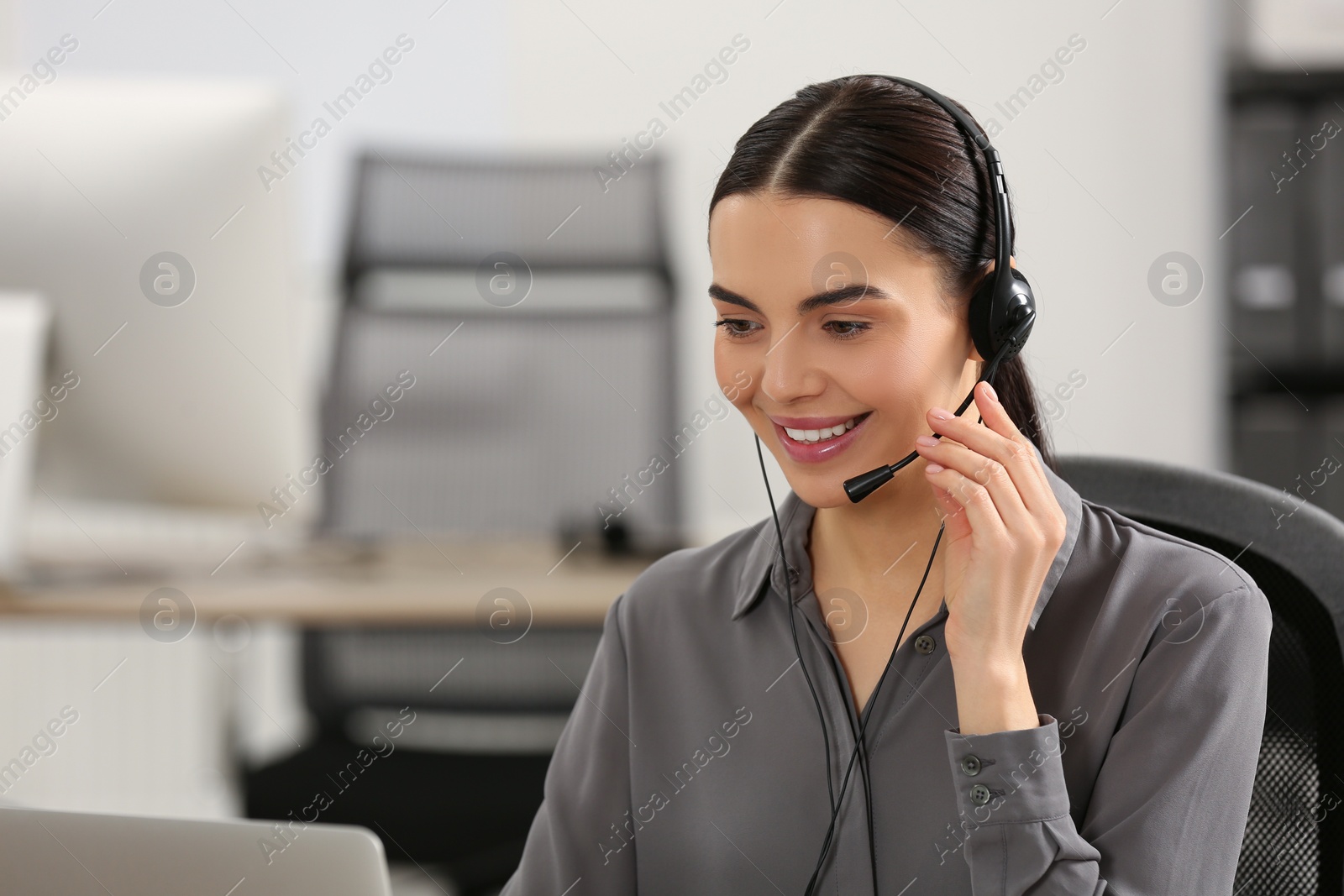 Photo of Hotline operator with headset working in office