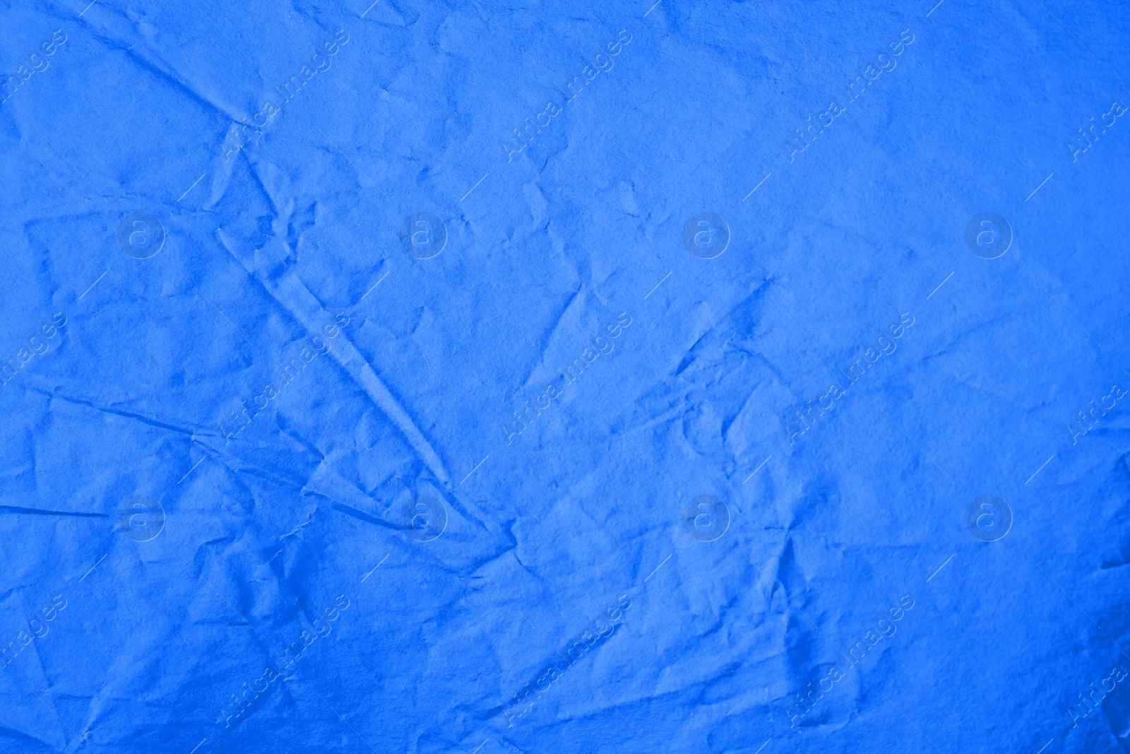 Photo of Sheet of crumpled blue paper as background, top view