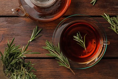 Photo of Aromatic herbal tea with rosemary on wooden table, flat lay