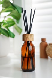 Air reed freshener on white table near window