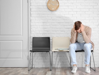 Photo of Young man waiting for job interview, indoors