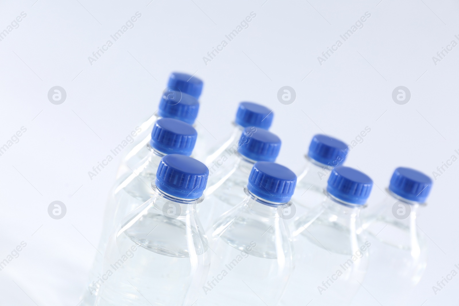 Photo of Plastic bottles with pure water on white background, closeup