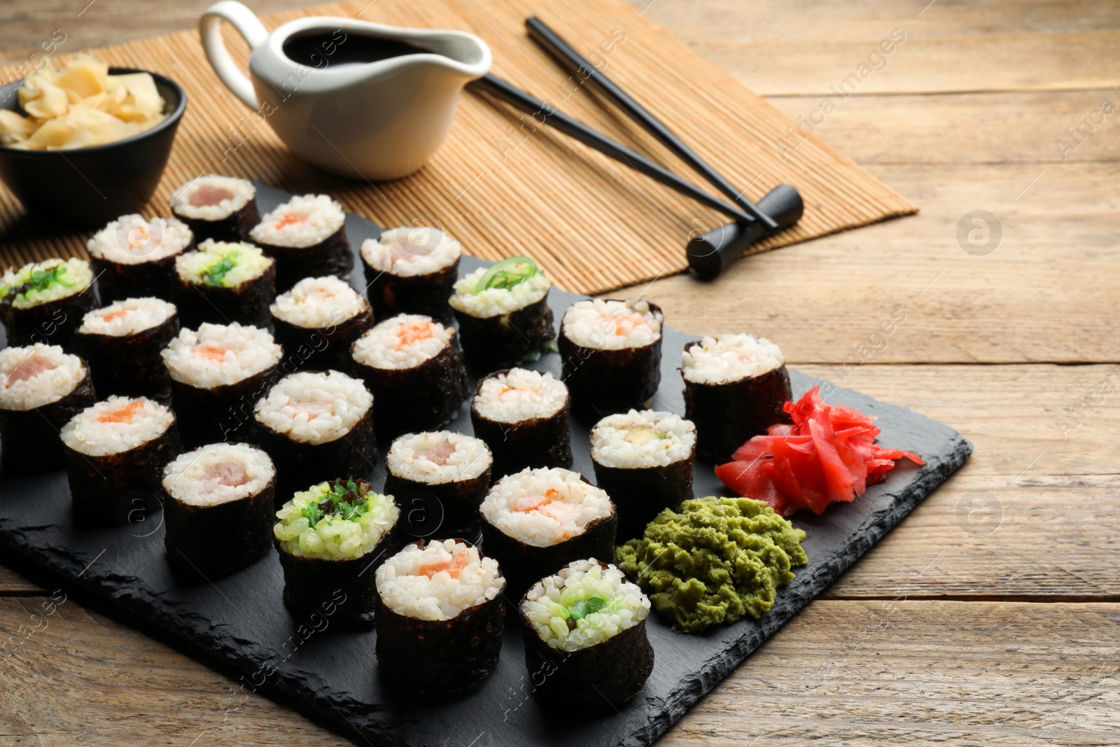 Photo of Tasty sushi rolls served on wooden table