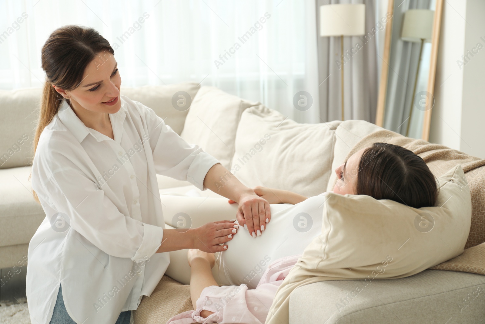 Photo of Doula taking care of pregnant woman at home. Preparation for child birth