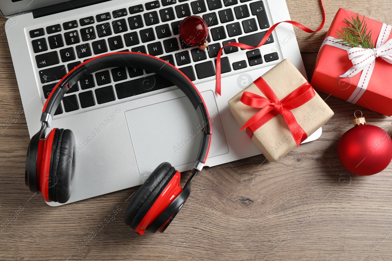 Photo of Flat lay composition with headphones on wooden background. Christmas music