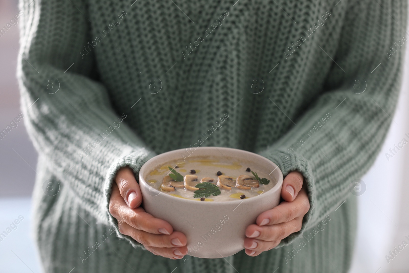Photo of Young woman with bowl of cream soup, closeup