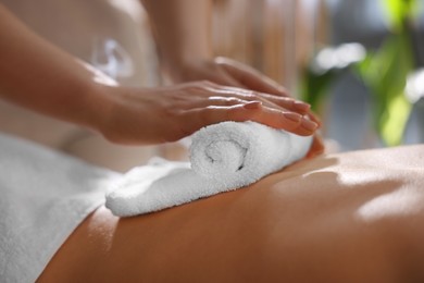 Photo of Spa therapy. Beautiful young woman lying on table during hot towel massage in salon, closeup