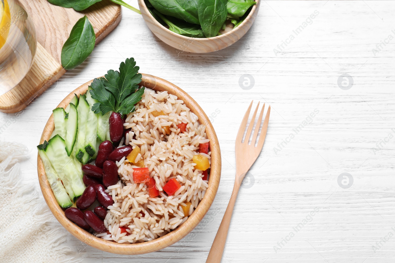Delicious rice with beans served on white wooden table, flat lay Photo of Delicious rice with beans served on white wooden table, flat lay