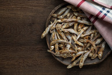 Delicious dried anchovies on wooden table, top view. Space for text