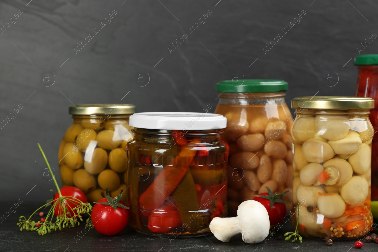Photo of Jars of pickled vegetables on grey background