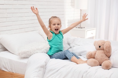 Cute little child playing on bed at home