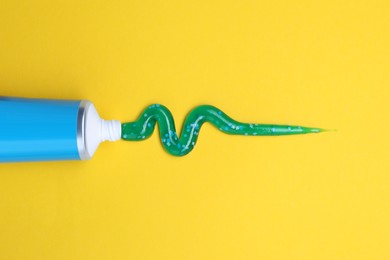 Photo of Tube of toothpaste on yellow background, flat lay