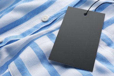 Cardboard tag with space for text on striped shirt, closeup