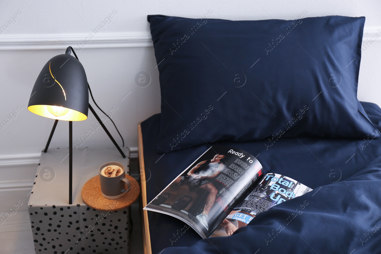 Photo of Open magazine on bed with stylish silky linens