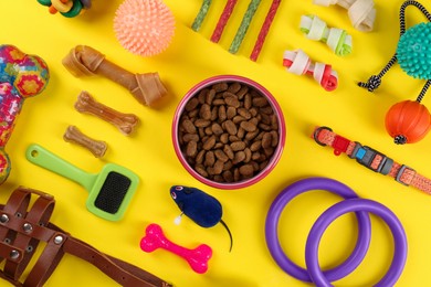 Photo of Flat lay composition with different pet goods on yellow background. Shop assortment