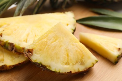 Slices of ripe juicy pineapple on wooden board, closeup