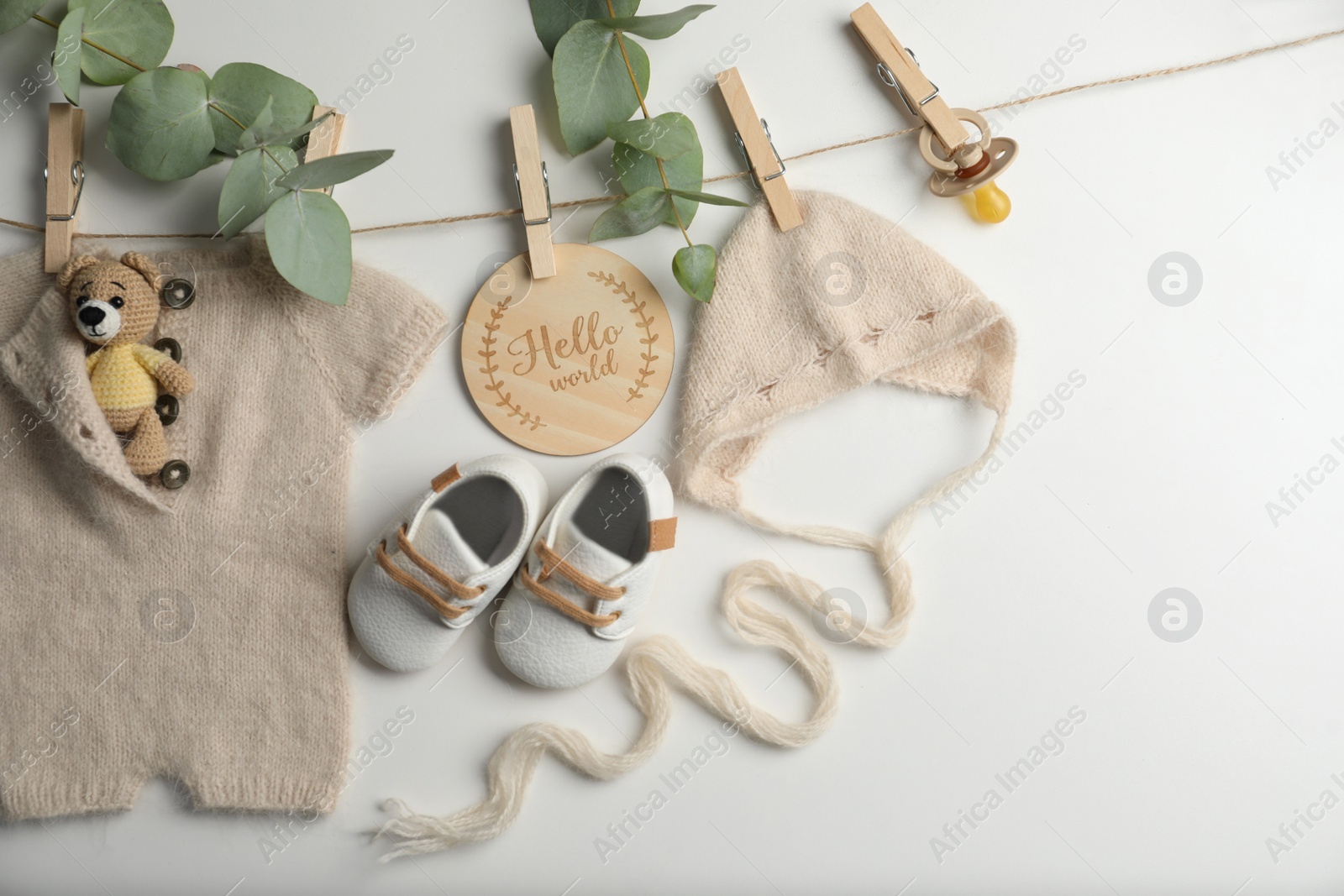 Photo of Baby clothes, shoes and accessories with washing line on light background, flat lay