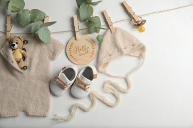 Baby clothes, shoes and accessories with washing line on light background, flat lay