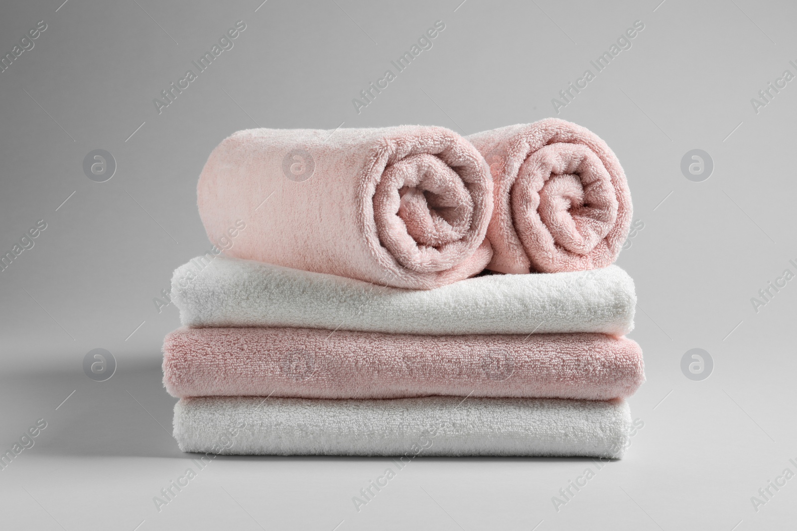 Photo of Stack of fresh towels on light background