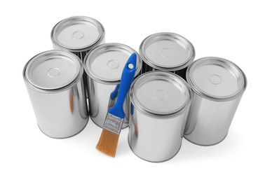 Photo of Cans of paints and brush on white background